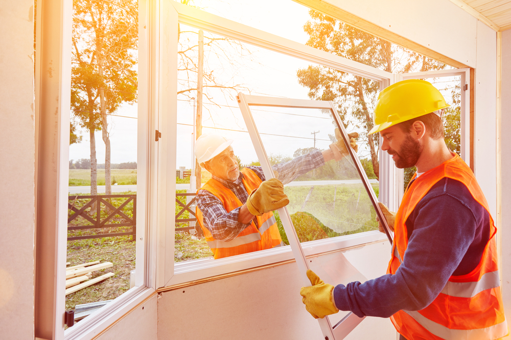 Budget Windows of Texoma installers fitting vinyl replacement windows on a home