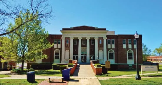 Southeastern Oklahoma State University campus in Durant OK—red brick buildings under bright blue sky, 1909 historic roots